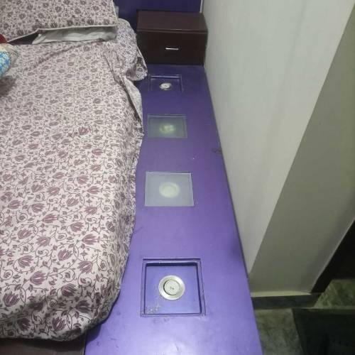 A low profile bed with mattress and side tables and dressing table 