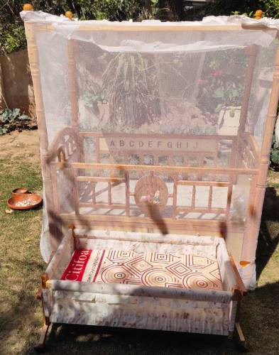 Wooden bed with baby cot swing